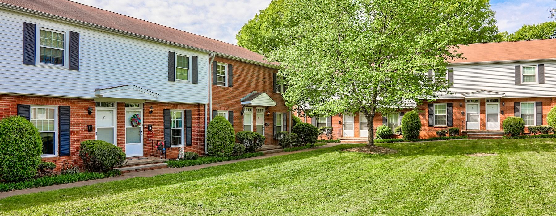 a large house with a lawn and trees in front of it