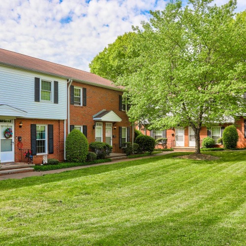 a large house with a lawn and trees in front of it