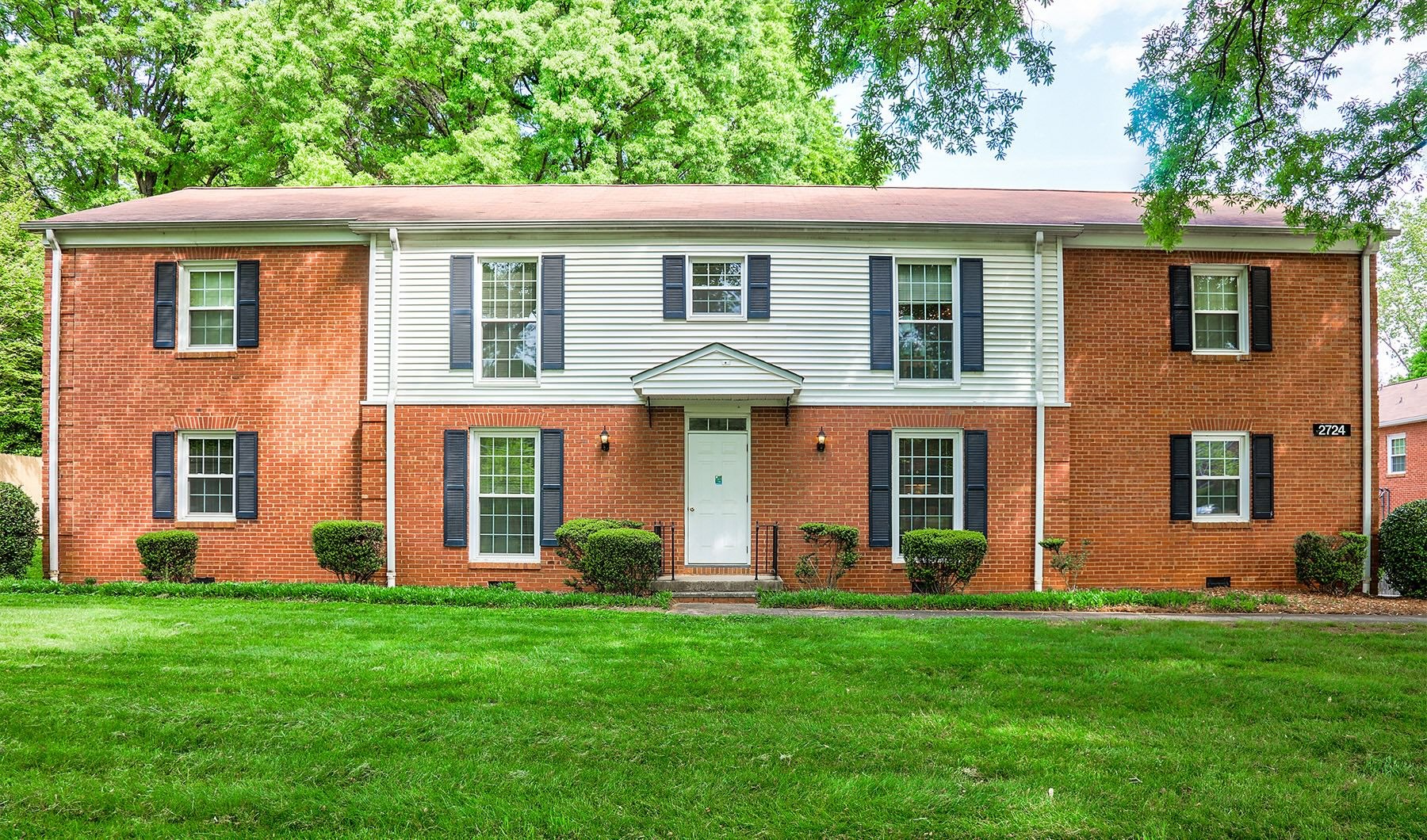a brick building with a green lawn